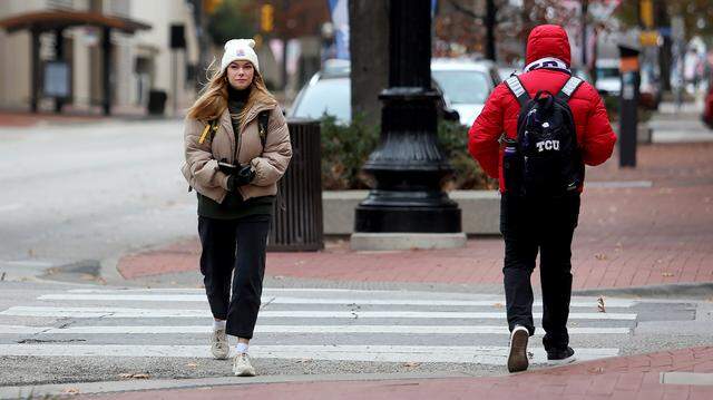 Pedestrians walk in downtown Fort Worth after temperatures plunged below freezing on Thursday, December 22, 2022.